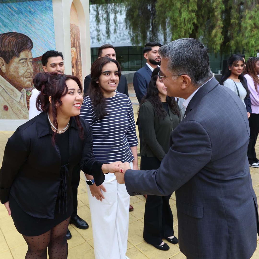 U.S. Secretary of Health and Human Services (HHS) Xavier Becerra shakes hands with Katy Reyes, ‘26 Aviation, during a recent visit to 菠菜网lol正规平台. Photo by David G. McIntyre.